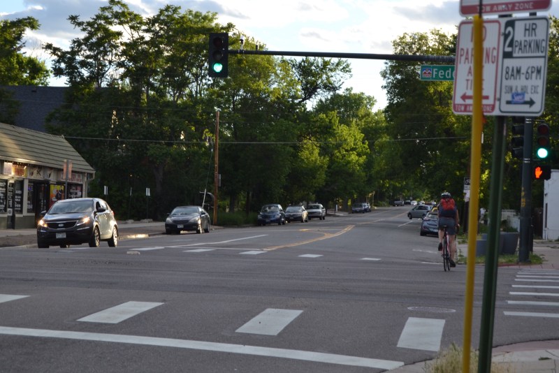 A bicyclist crosses Federal on West 23rd Avenue, an intersection where some white stripes would make a big difference. Photo: David Sachs