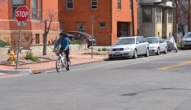 A bicyclist at a stop sign.