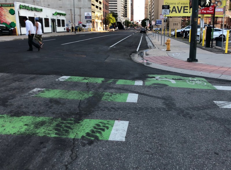 A bike crossing, obscured by tire marks, once took riders onto the Arapahoe Street protected bike lane. Not anymore. Photo: David Sachs