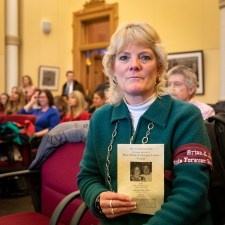 Susan Dane of CORD held up a funeral program of two friends killed by a distracted driver. "I've never been to a funeral with two caskets, with the husband and the wife." Photo: Andy Bosselman, Streetsblog.
