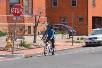 A bicyclist at a stop sign.