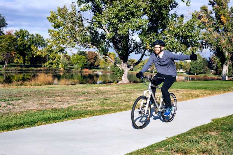 Loren Hansen riding a bike and giving the thumbs up sign (Photo by Michelle Deyden)