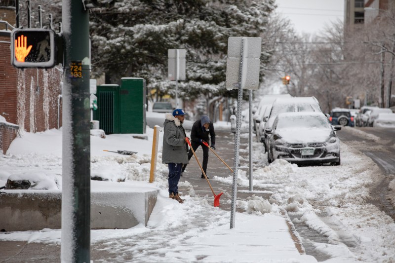 Photo Two men shovel snow