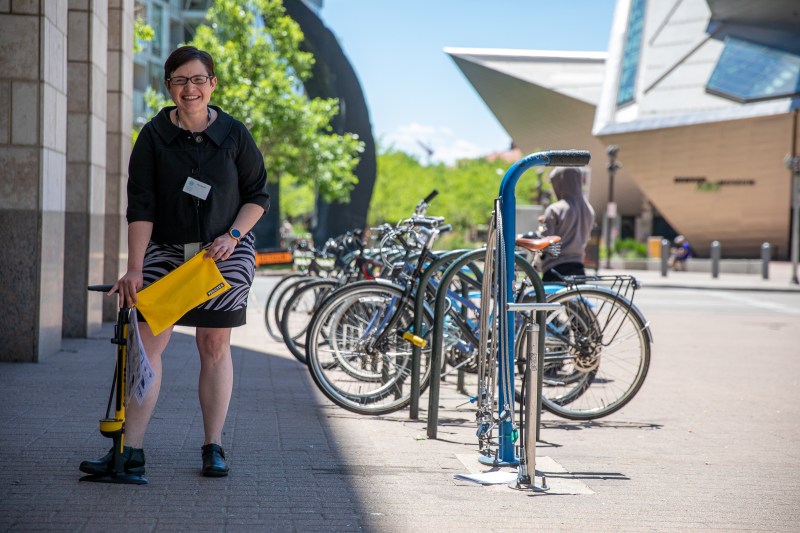 Amanda Armstrong, a business librarian, poses with a new bike kit next to a fixed repair station outside of the Central Library this afternoon. Photo: Andy Bosselman