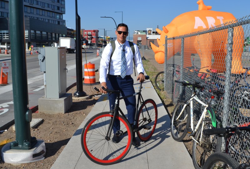 An unidentified cyclist poses for a photo hear a Bike to Work Day station in RiNo last year. Image: DRCOG via Flickr.
