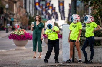 A woman wearing an eyeball mask dances to draw attention to pedestrian safety. Photo: Andy Bosselman