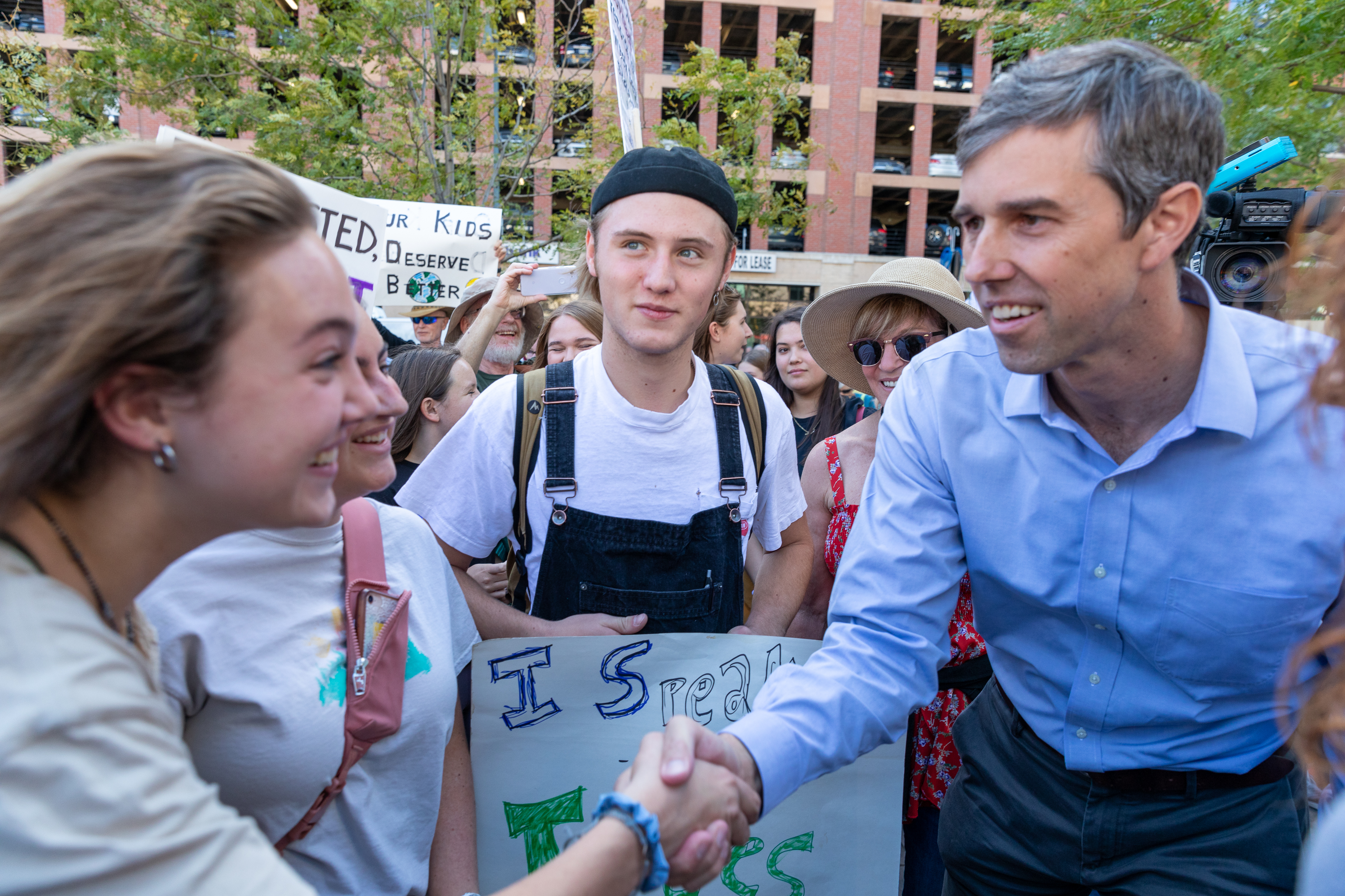 Presidential candidate Beto O'Rourke shakes hands with a youth protestor at Union Station.