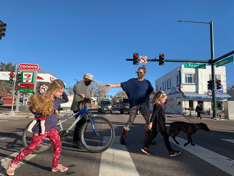 image caption: Kate Gotter hurries her children through the crosswalk at Pearl and Alameda.