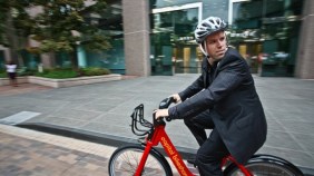 Person riding a Capital Bikeshare bike on the street