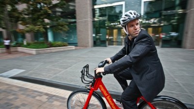 Person riding a Capital Bikeshare bike on the street