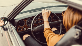 Woman in driver's seat of car with window down