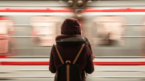 Person stands on platform next to train