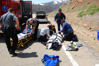 People treat a person lying on the road at a crash