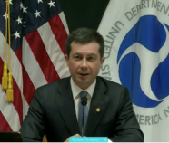 Pete Buttigieg with U.S. flag and USDOT flag